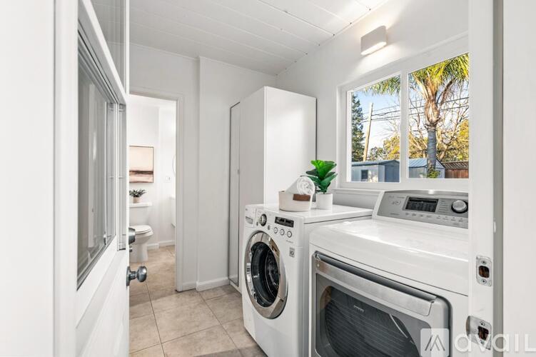 A white laundry room with a washer and dryer.