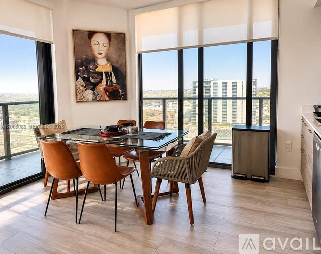 A dining room with a glass table and chairs with a painting on the wall.