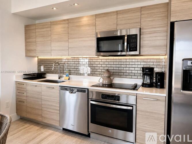 A modern kitchen with stainless steel appliances and wooden cabinets.