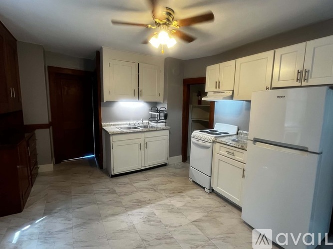 A kitchen with white appliances and cabinets.