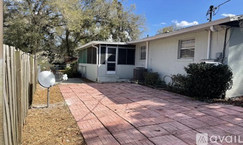A house with a white exterior and a brick patio.
