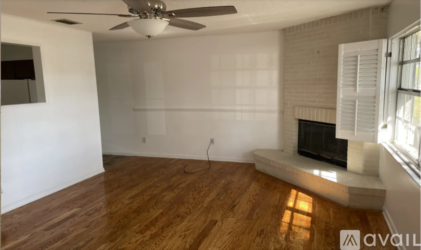 A room with a fireplace and a ceiling fan.