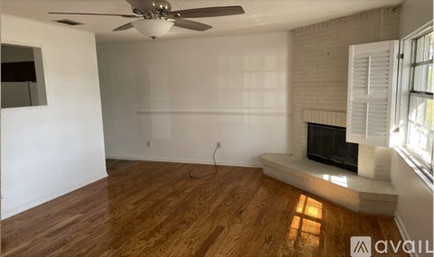 A room with a fireplace and a ceiling fan.