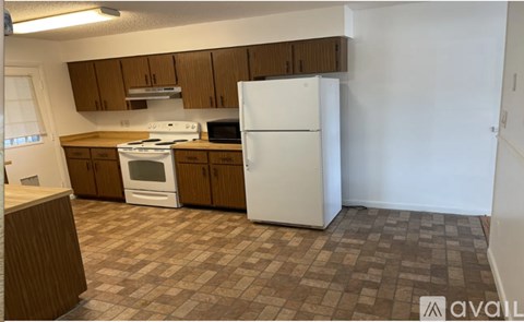 A kitchen with a white refrigerator, stove, and oven.