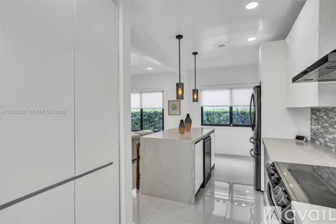 A modern kitchen with a white countertop and stainless steel appliances.