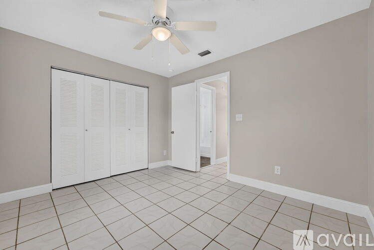 A room with a ceiling fan and tiled flooring.