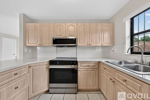 A kitchen with wooden cabinets and a black oven.