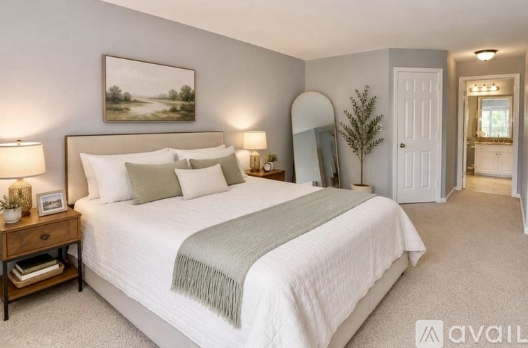 A bedroom with a large bed and a painting on the wall.
