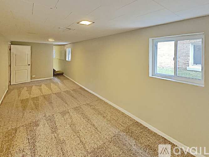 A room with a carpeted floor and a window.