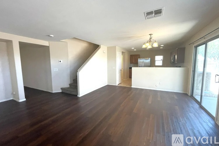 A spacious living room with hardwood floors and a staircase leading to the upper level.