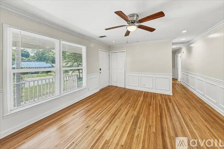 A room with a ceiling fan and carpeted floor.