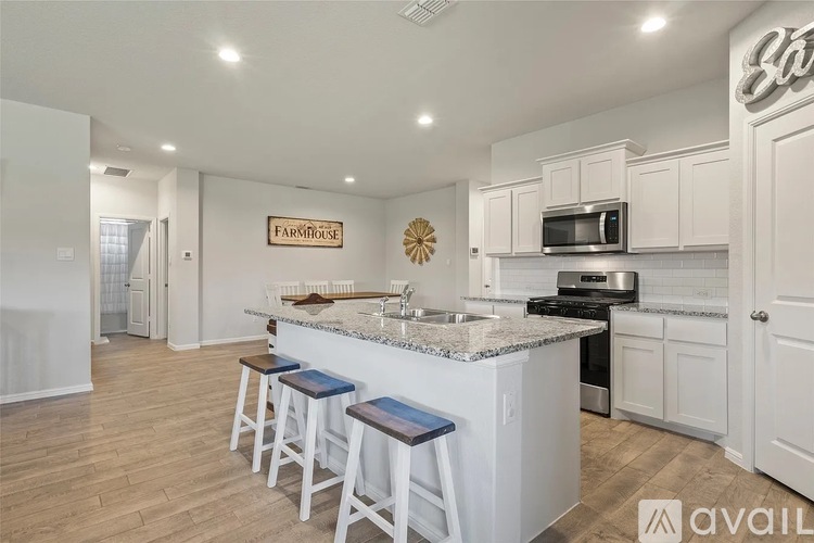 A kitchen with white cabinets and a granite countertop.