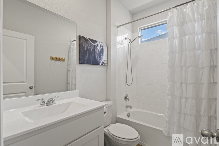 A white bathroom with a toilet, sink, and bathtub.