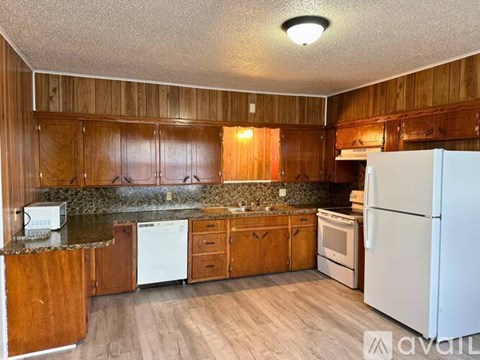 A kitchen with wooden cabinets and a white refrigerator.