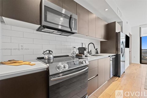 A modern kitchen with a stove top oven and a microwave above it.
