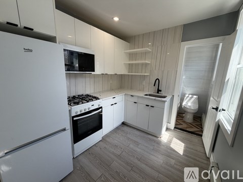 A kitchen with white appliances and cabinets.