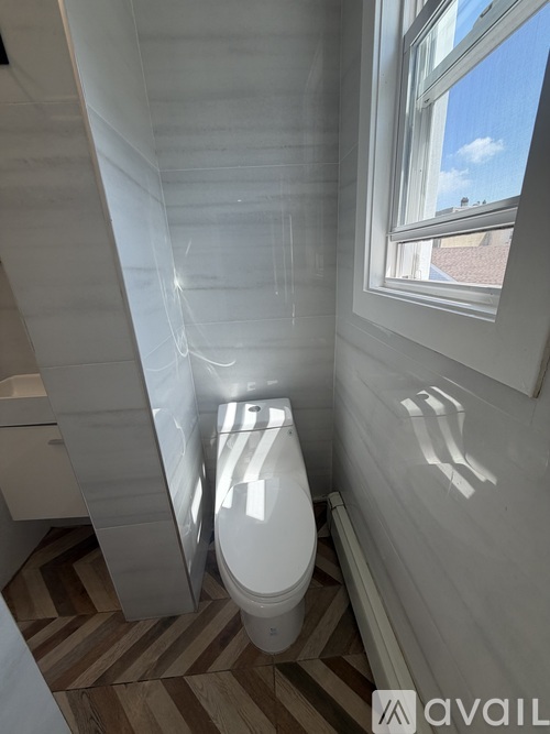 A bathroom with a toilet and a window.