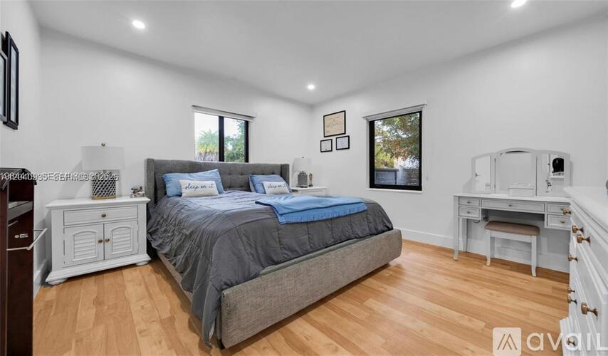 A bedroom with a bed, desk, and chair.