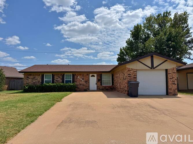 A house with a driveway and a tree in front.