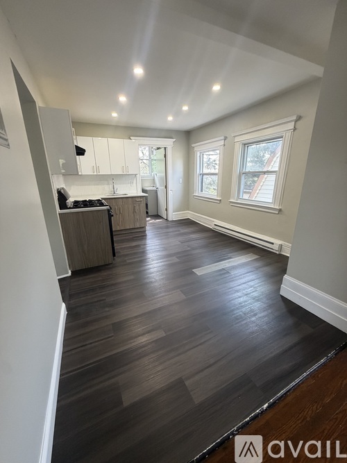 A kitchen with wooden floors and white walls.