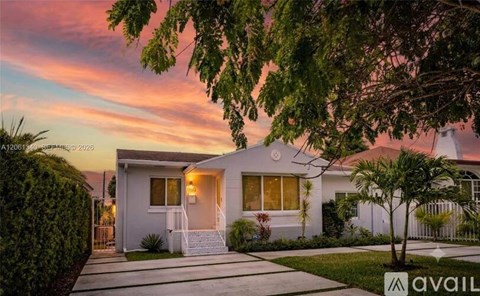 A modern house with a white exterior and a front porch is for sale.