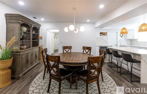 A dining room with a wooden table surrounded by chairs.