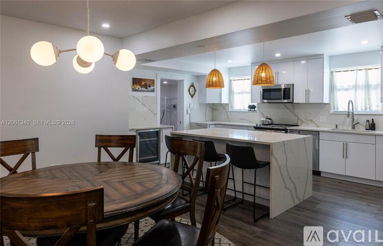 A modern kitchen with a wooden table and chairs.