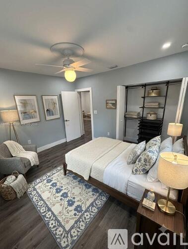 A bedroom with a bed, a chair, and a rug.