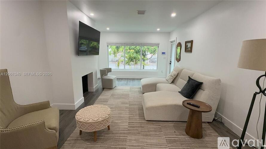 A living room with a flat screen TV mounted on the wall.