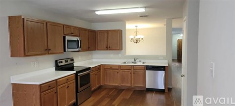 A kitchen with wooden cabinets and a white countertop.