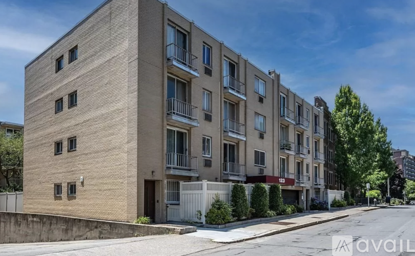A street view of apartment buildings with balconies and windows.