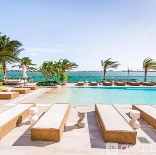 A poolside area with sun loungers and palm trees.
