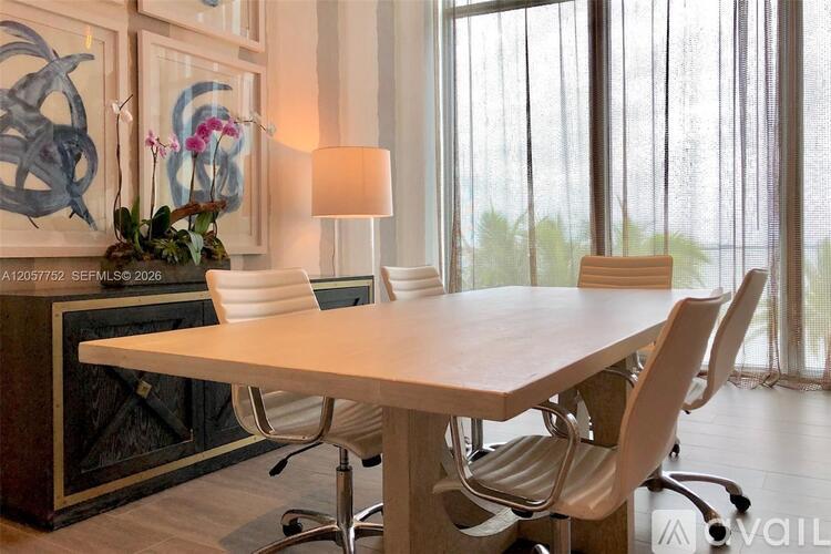 A modern dining room with a large table and chairs.