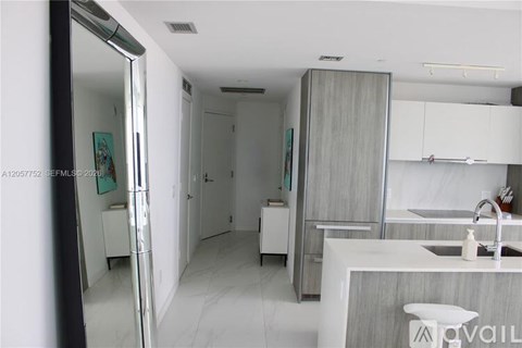 A modern kitchen with white cabinets and a marble countertop.