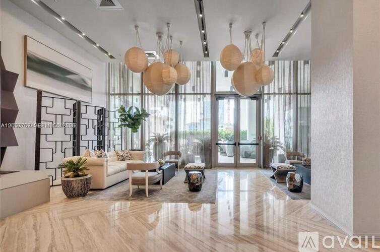 A spacious living room with a large window, a sofa set, and a coffee table.