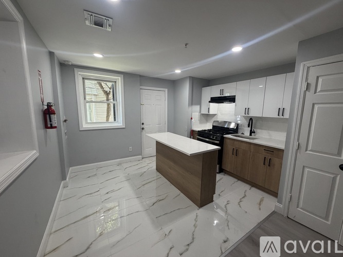 A kitchen with a marble floor and white walls.