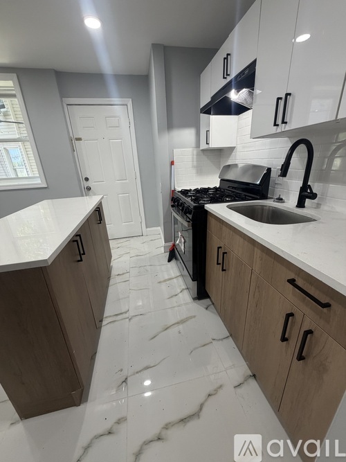 A kitchen with a white counter top and marble floor.