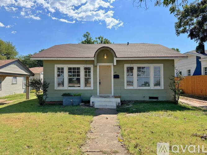 A house with a front yard and a pathway leading to the front door.