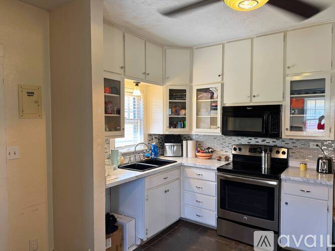 A kitchen with white cabinets and a black stove top.