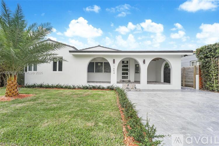 A white house with a palm tree in front and a sign that says "AVAILABLE".