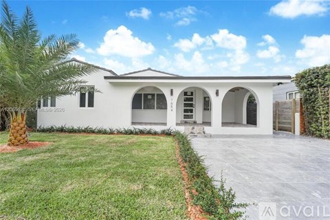 A white house with a palm tree in front and a sign that says "AVAILABLE".