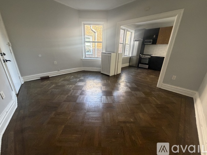 A room with wooden flooring and a window letting in natural light.
