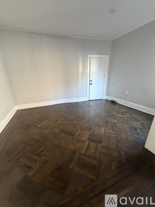 A room with a wooden floor and a white door.