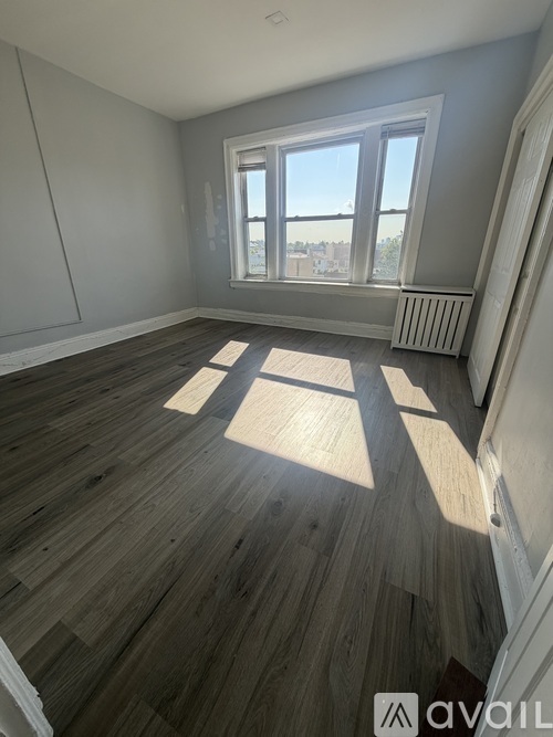 A room with wooden flooring and a large window.