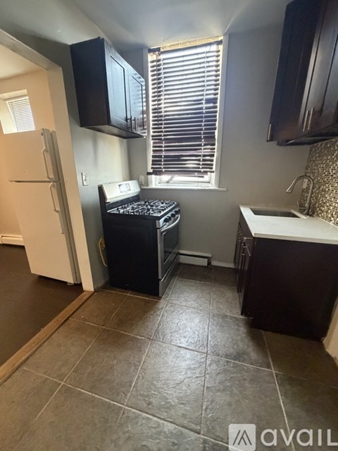 A kitchen with black cabinets and a white fridge.