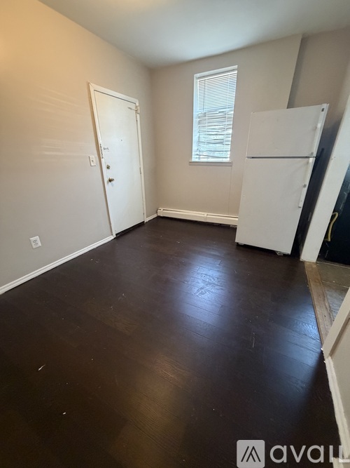 A room with a white door and a window with blinds.