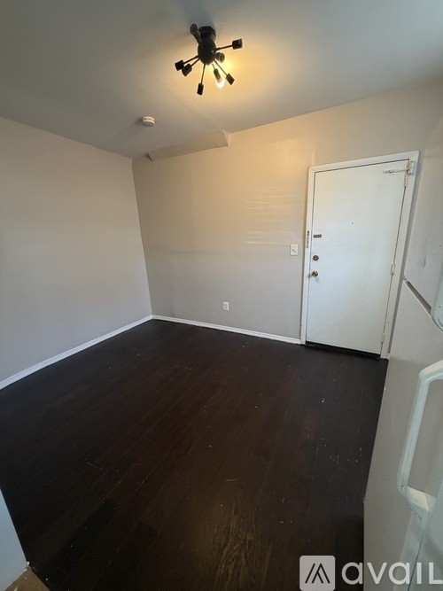 A room with a white door and a ceiling fan.