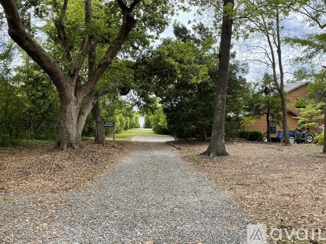 A gravel pathway surrounded by trees in a park-like setting.