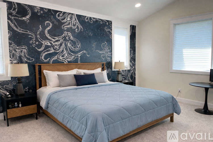A bedroom with a large bed and a blue comforter.