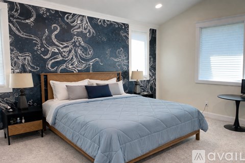A bedroom with a large bed and a blue comforter.